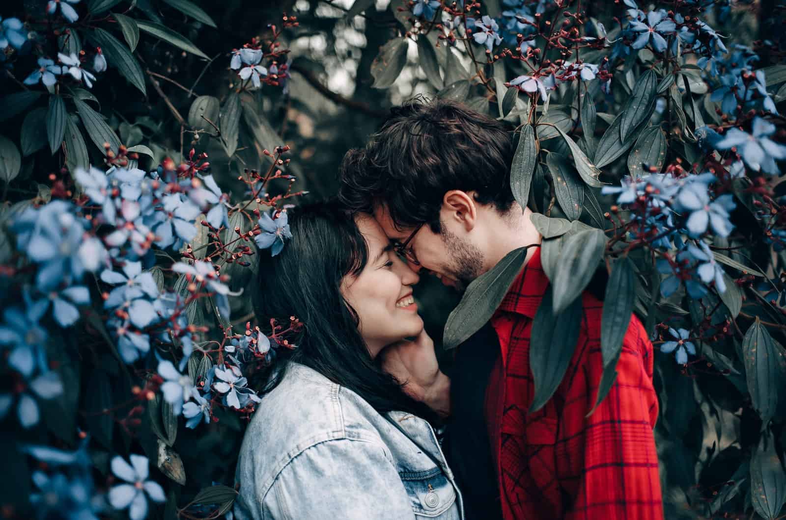 couple kissing surrounded by plants