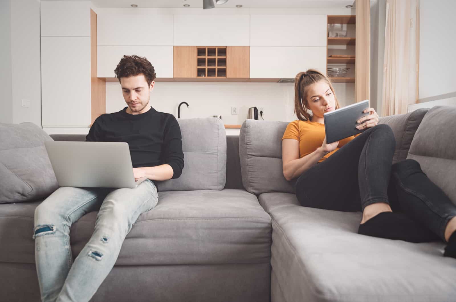 couple sitting on sofa and working