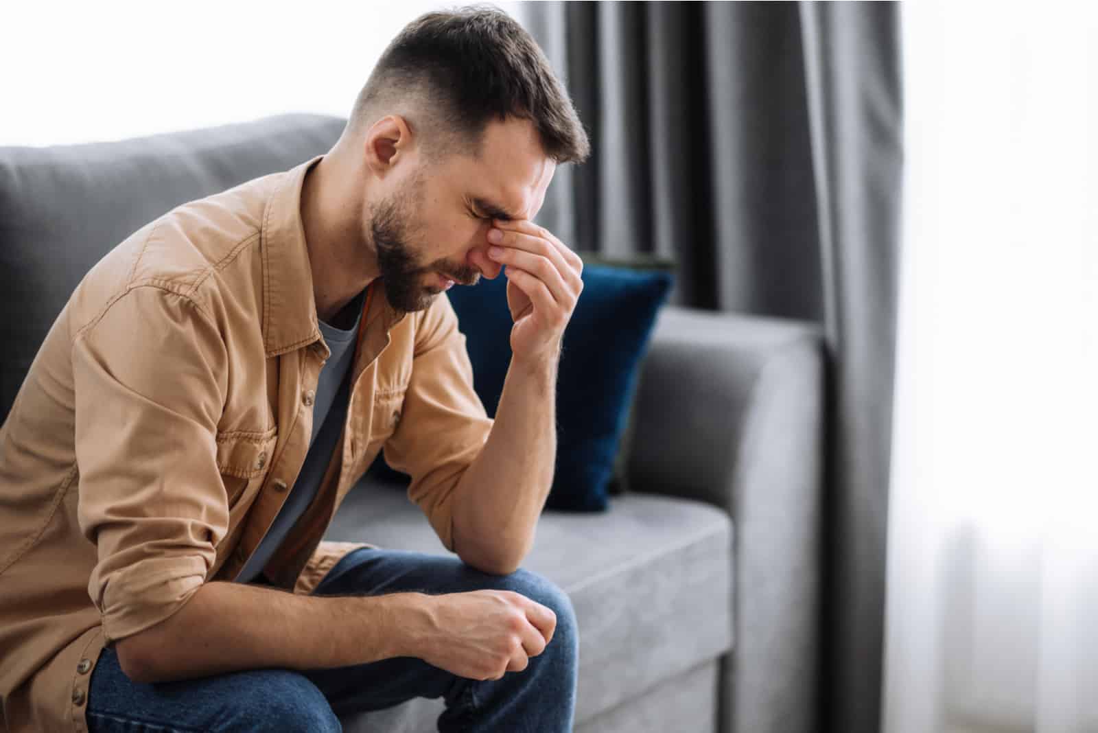 distressed man sitting on sofa