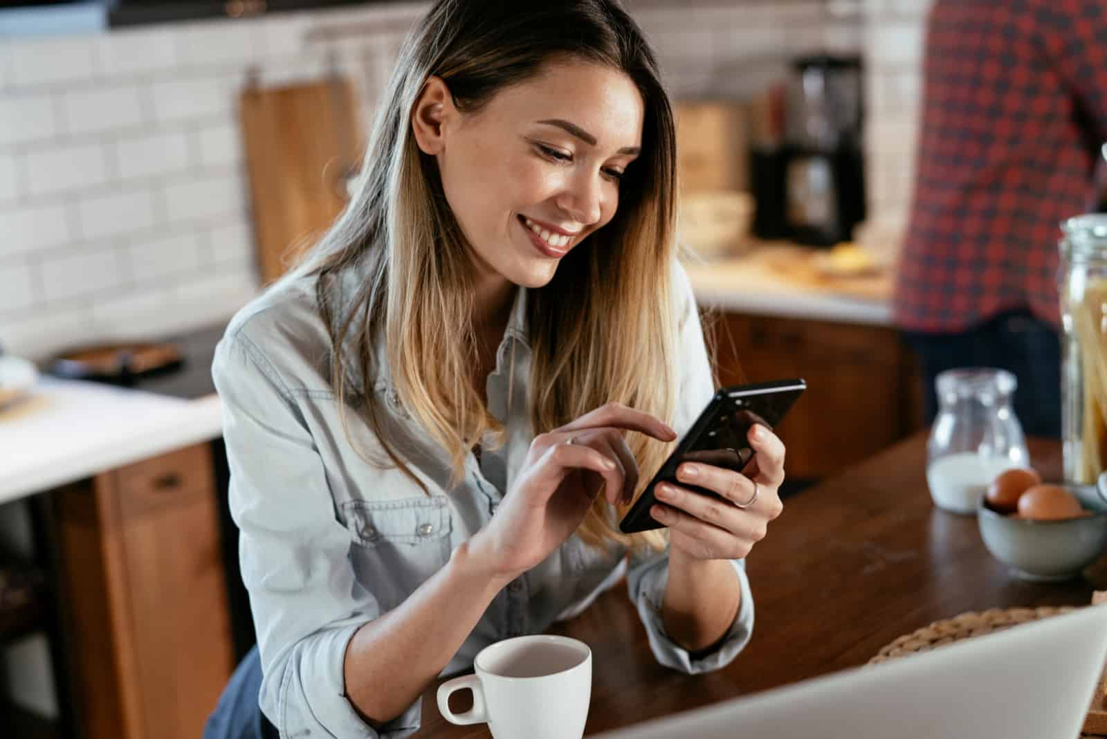 mulher feliz a escrever no telemóvel