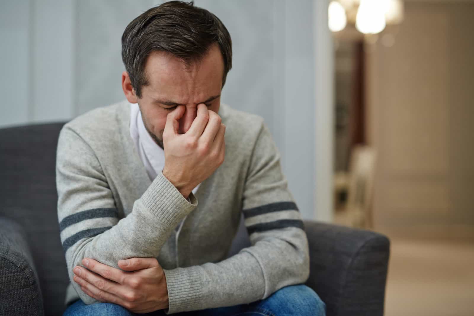 man crying on sofa