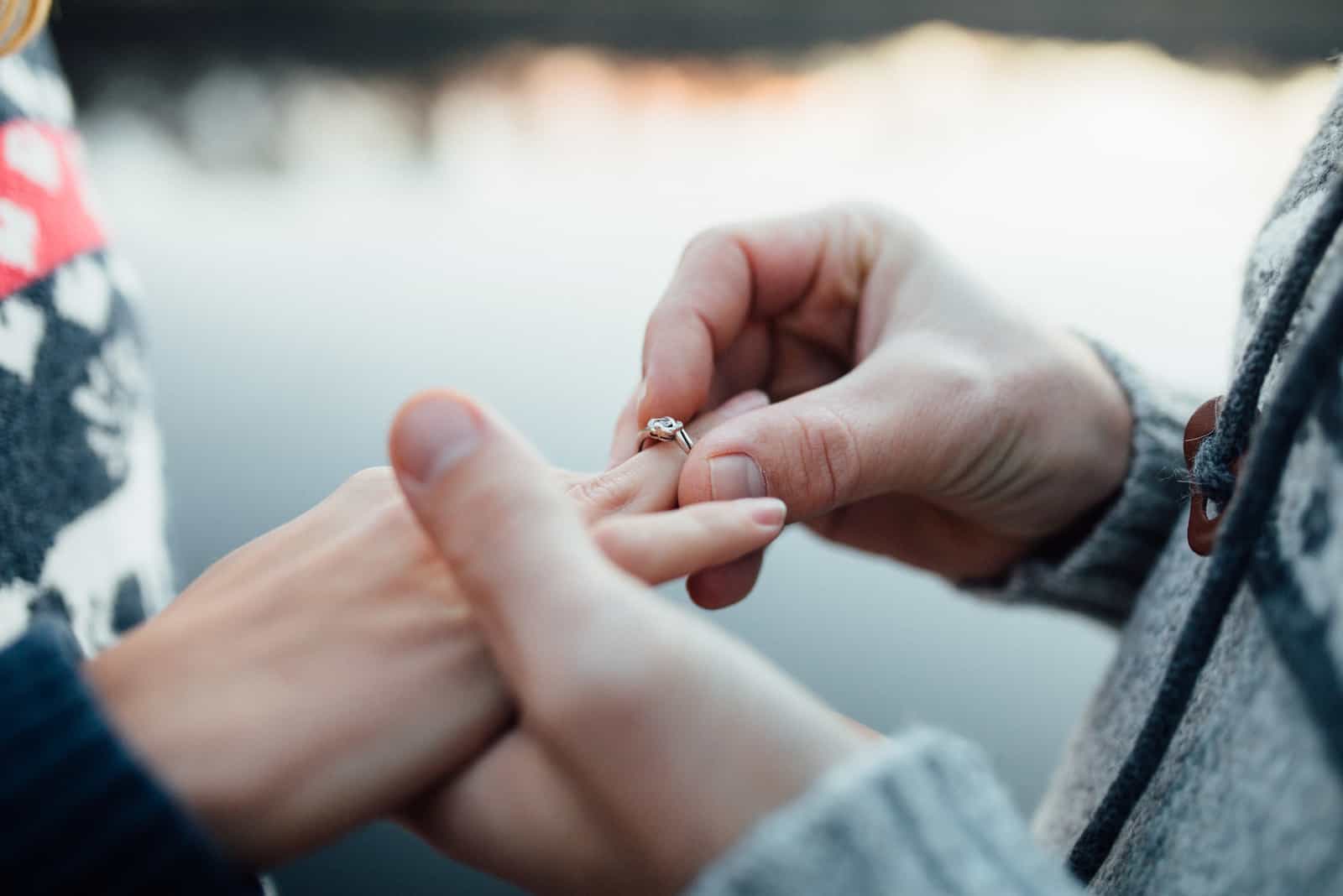 homem a pedir uma rapariga em casamento com um anel de diamantes