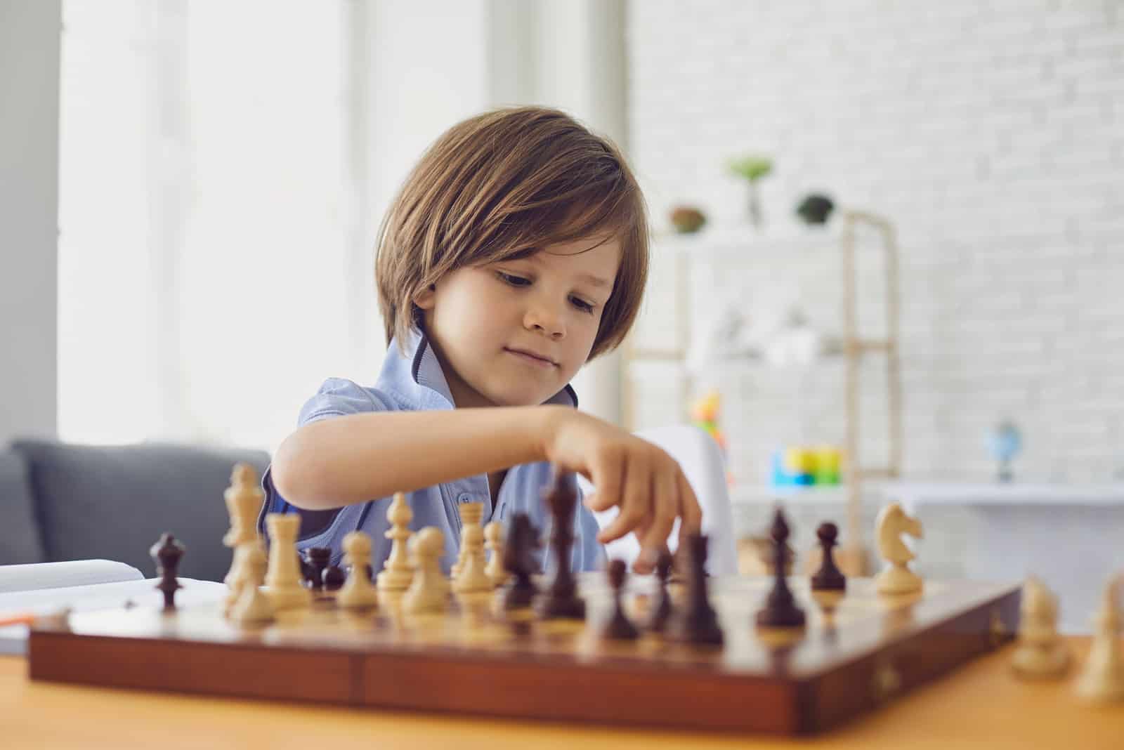 smart boy playing chess at home