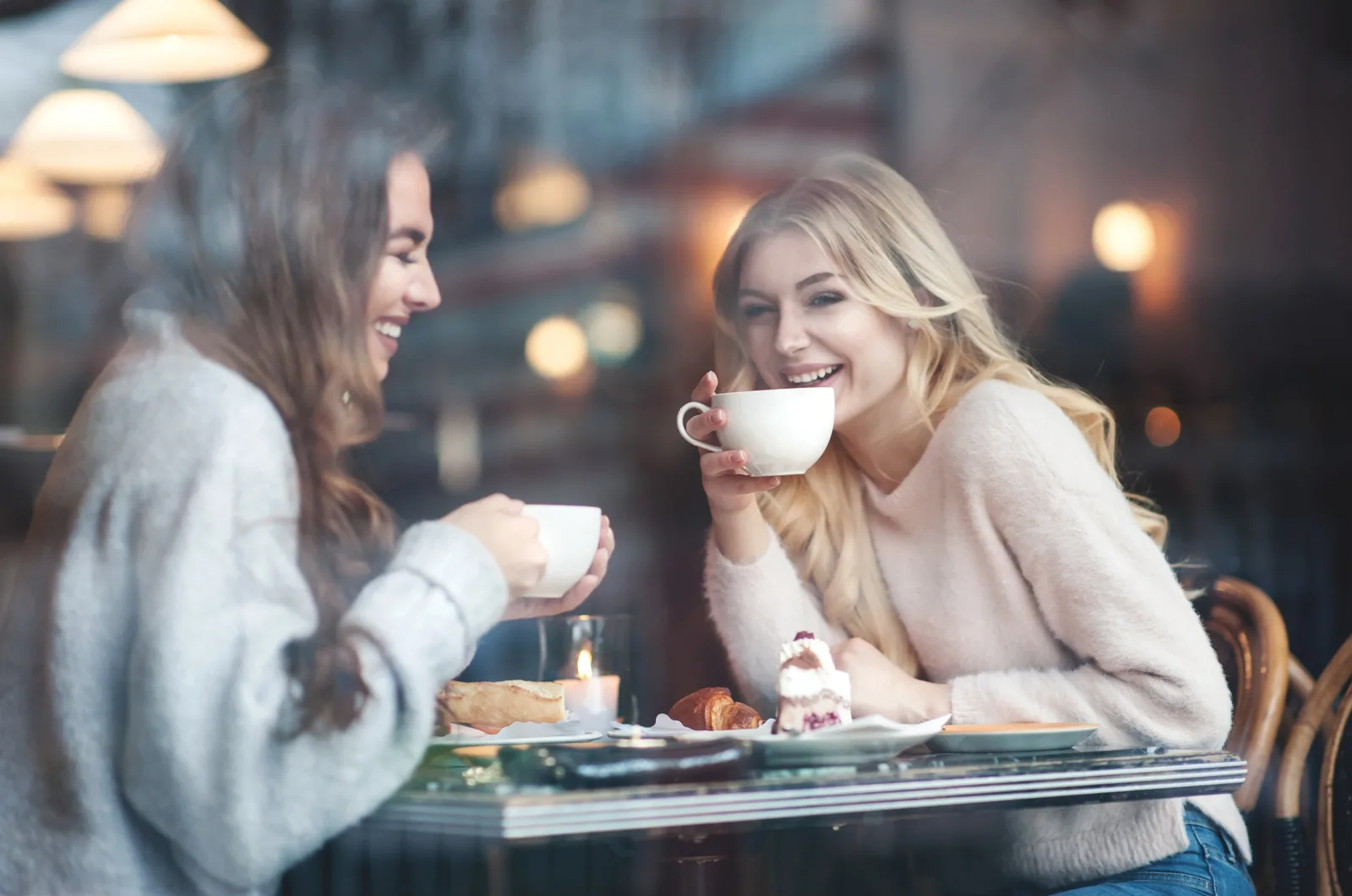 two women sitting in cafe drinking coffee