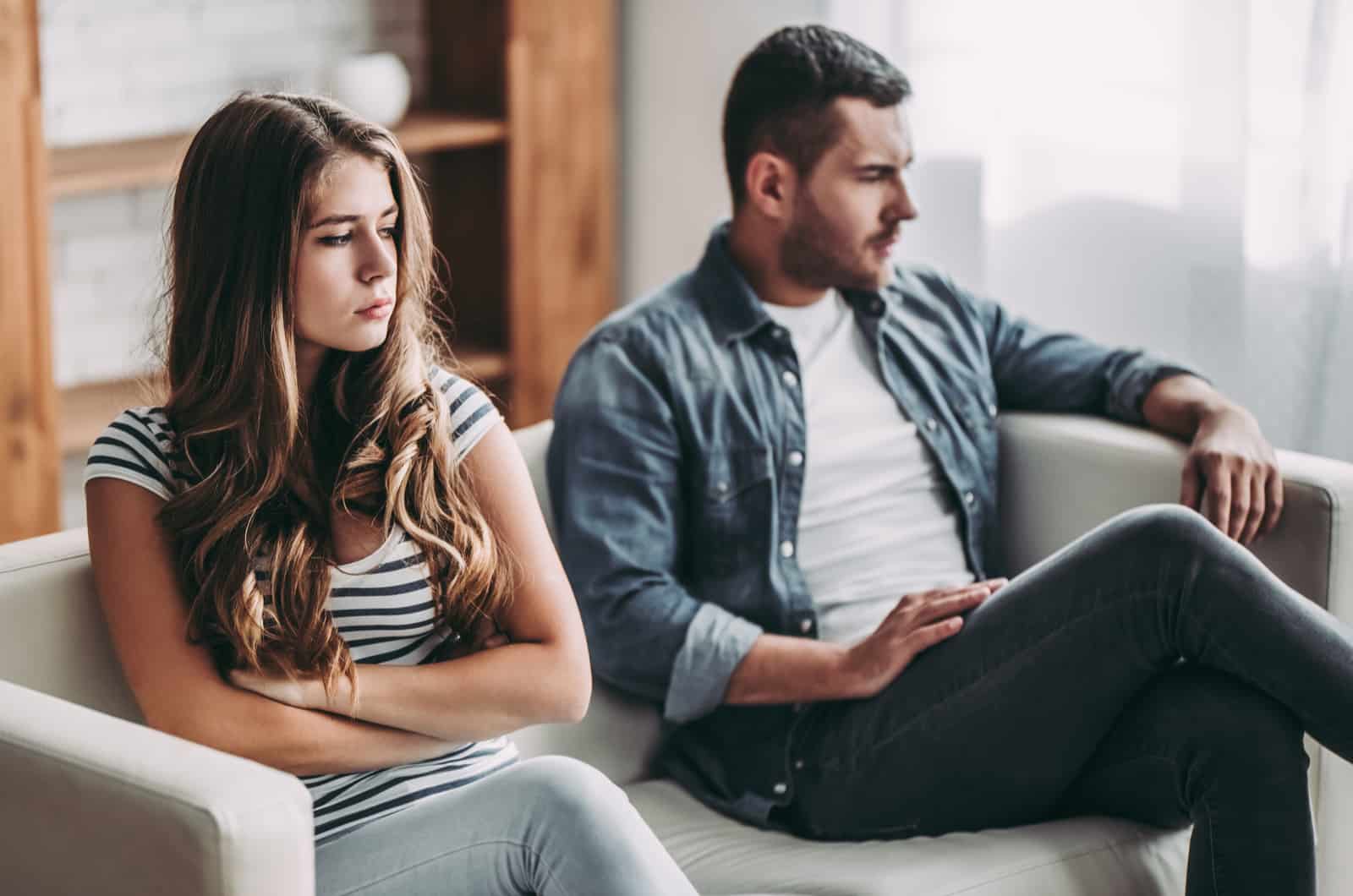 unhappy couple sitting on sofa after fight