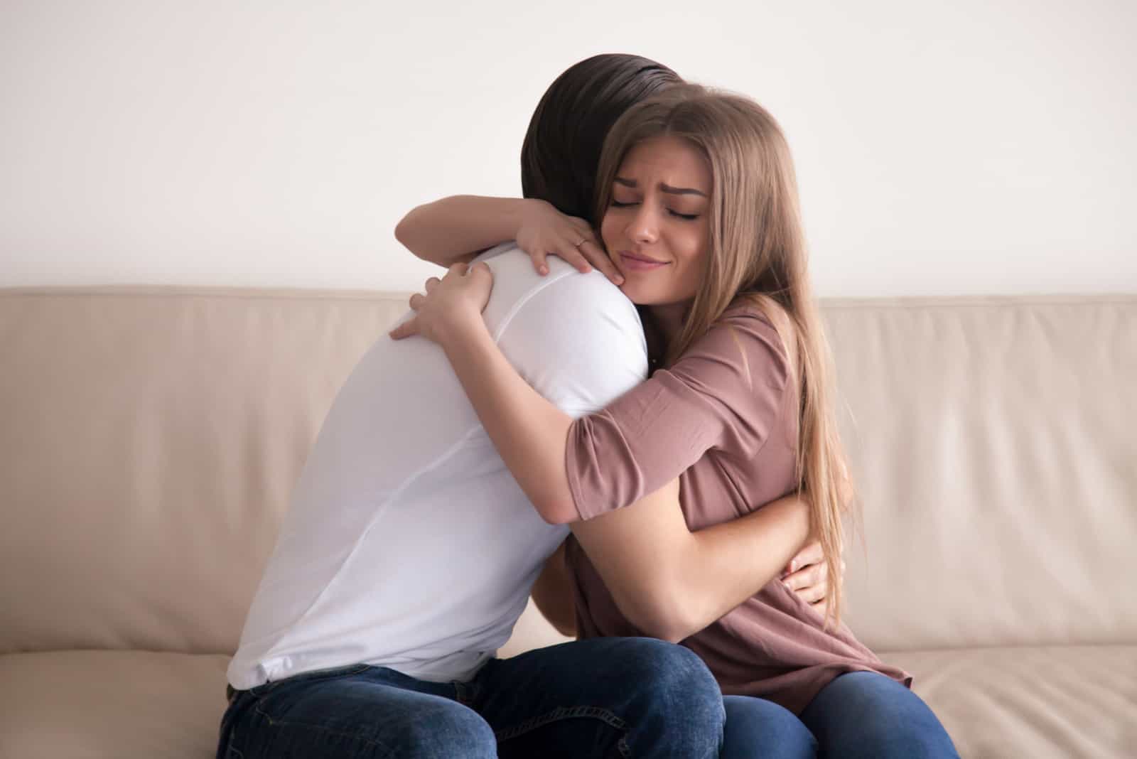 mujer abrazando a su novio angustiada