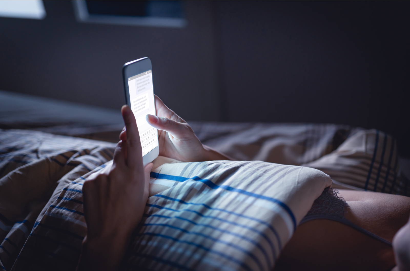 woman in bed texting