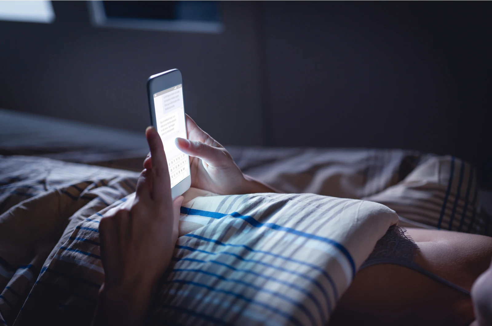 woman in bed texting