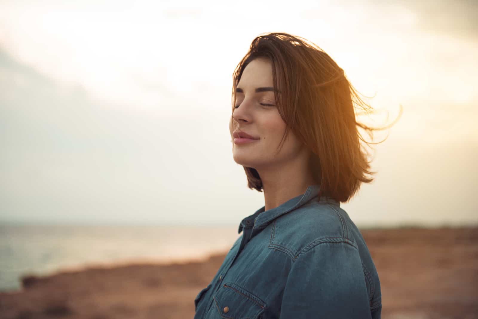 mulher na natureza com os olhos fechados