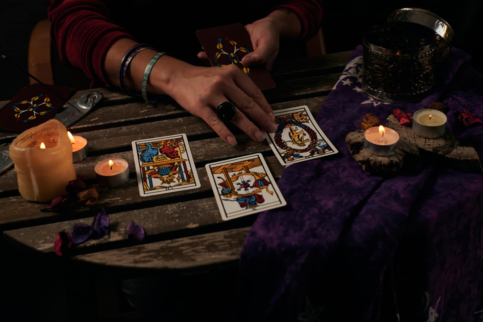 woman reads tarot cards on a table with candles