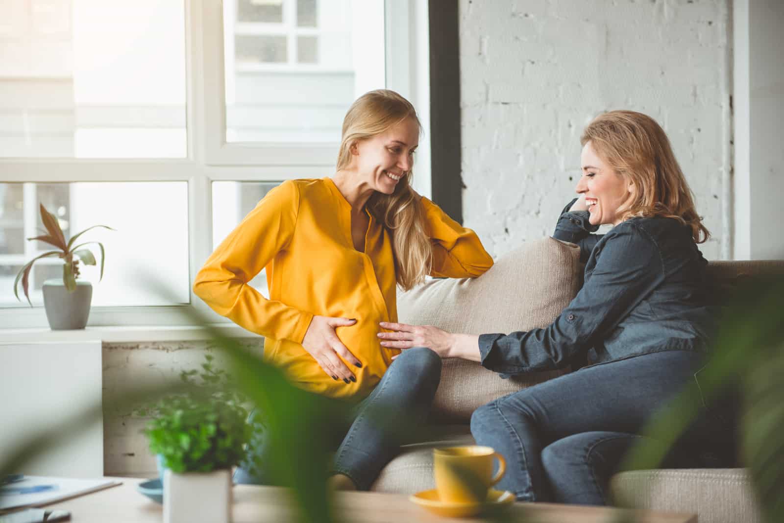 woman touching friends pregnant belly
