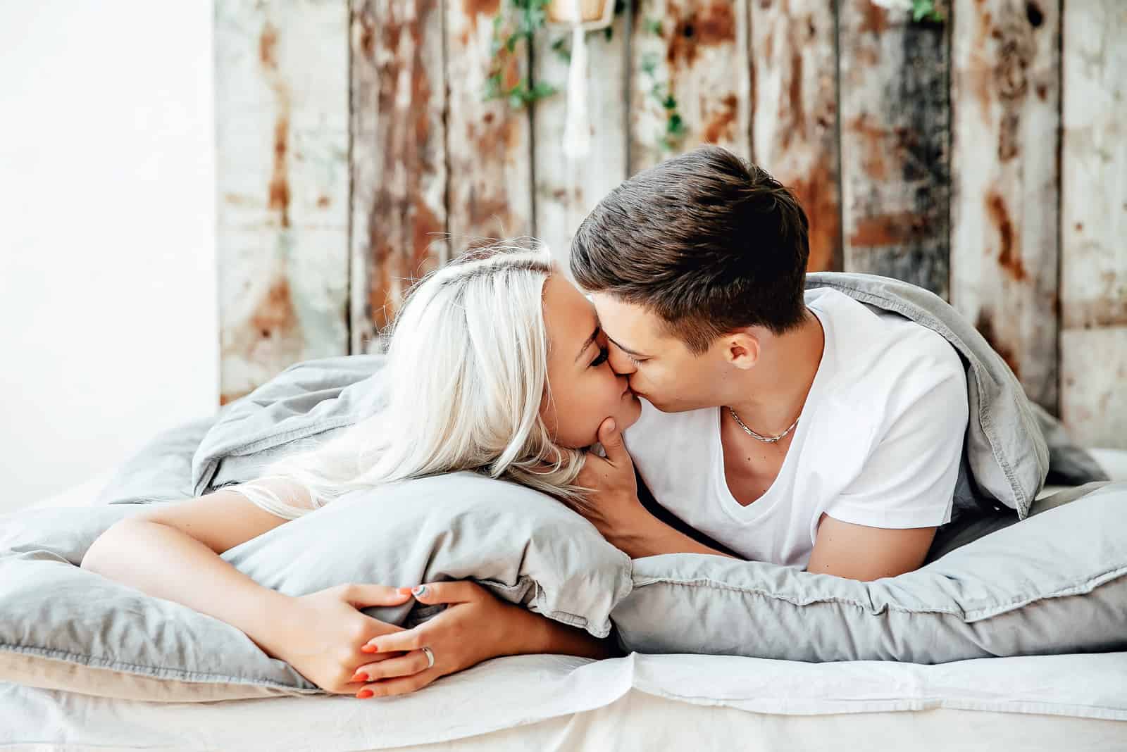 jovem casal a beijar-se na cama