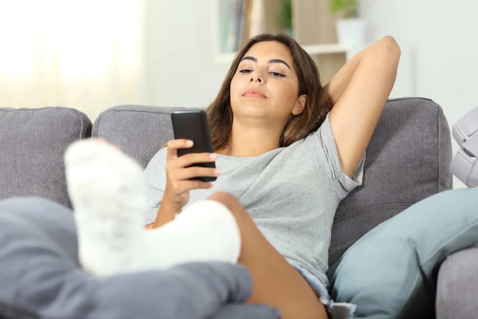 young woman texting on the couch