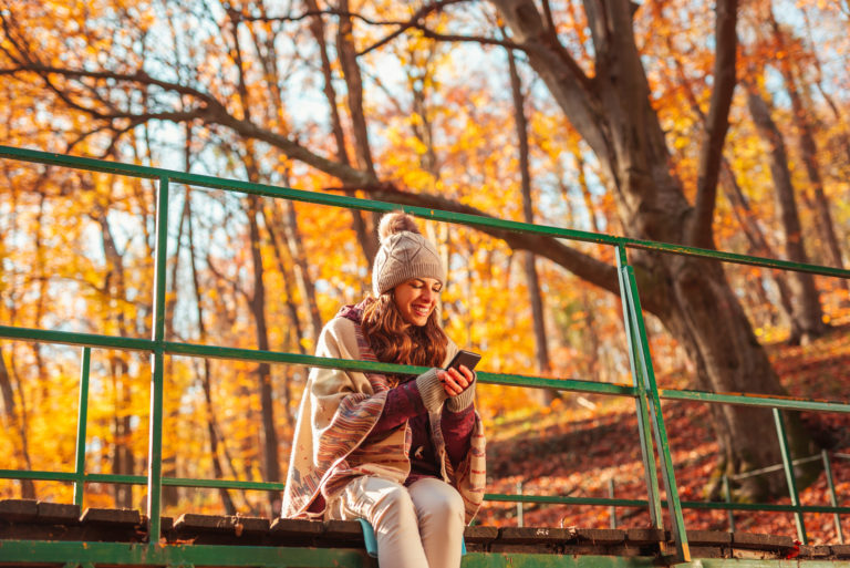 girl sittig in nature on her phone