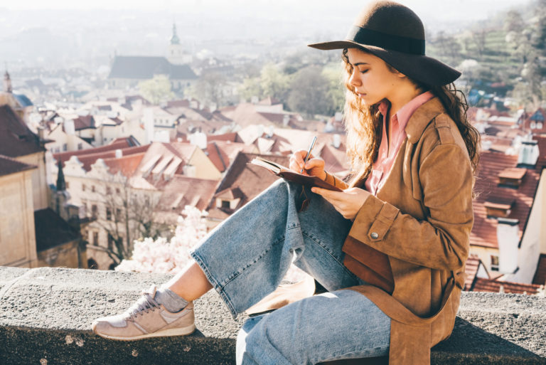 girl sitting outside writing