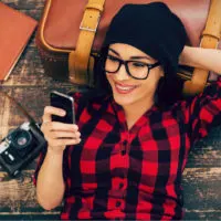 a beautiful girl lying on a pier and holding a phone in her hand