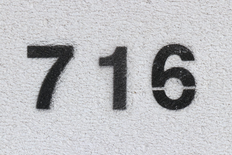 número 716 en pared gris