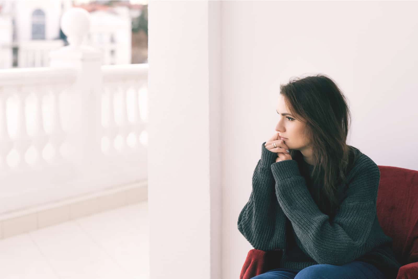 a sad woman sits on the sofa and looks away