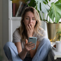 upset woman looking at her phone