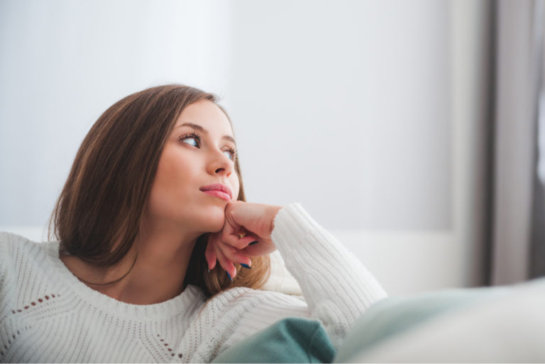 woman in a white sweater thinking