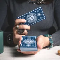 a woman holds tarot cards in her hand