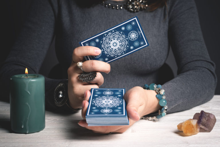 a woman holds tarot cards in her hand
