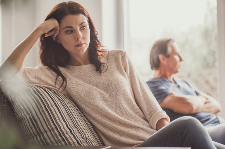 couple sitting on sofa after fight