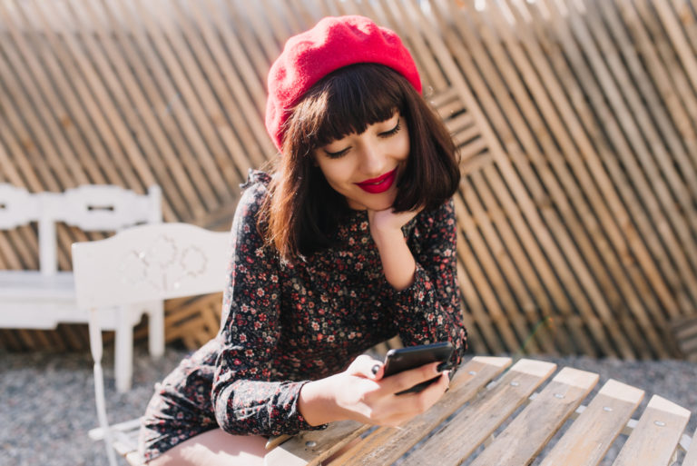 una chica sonriente con un teléfono en la mano