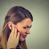 una bella mujer tiene un problema de dolor de oídos