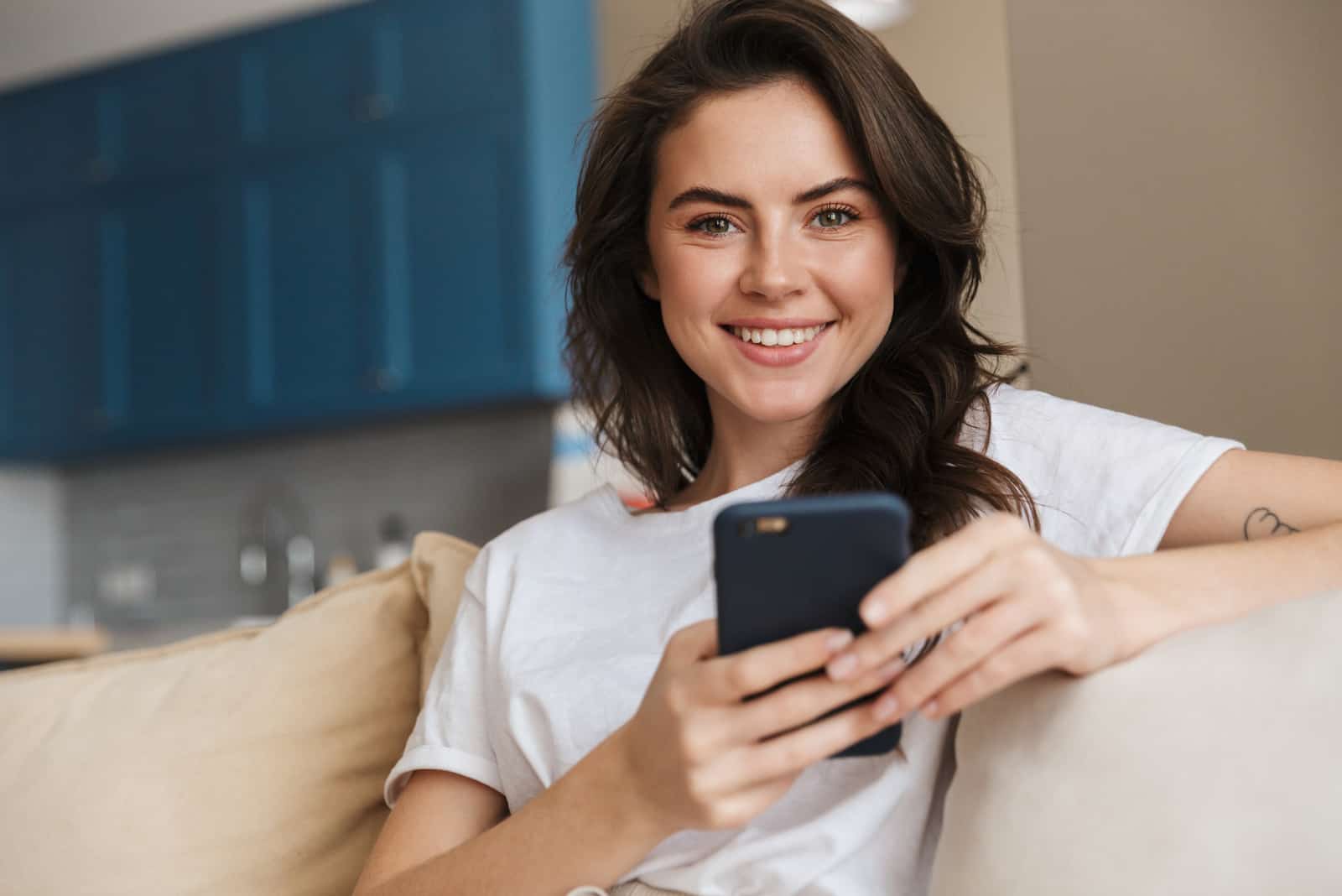 a beautiful black haired woman holds a phone in her hand