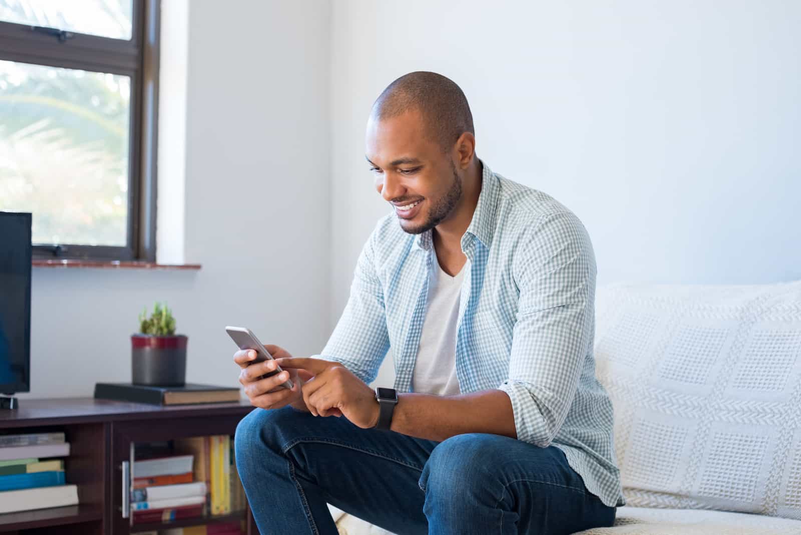 um homem senta-se em casa e bate ao telefone