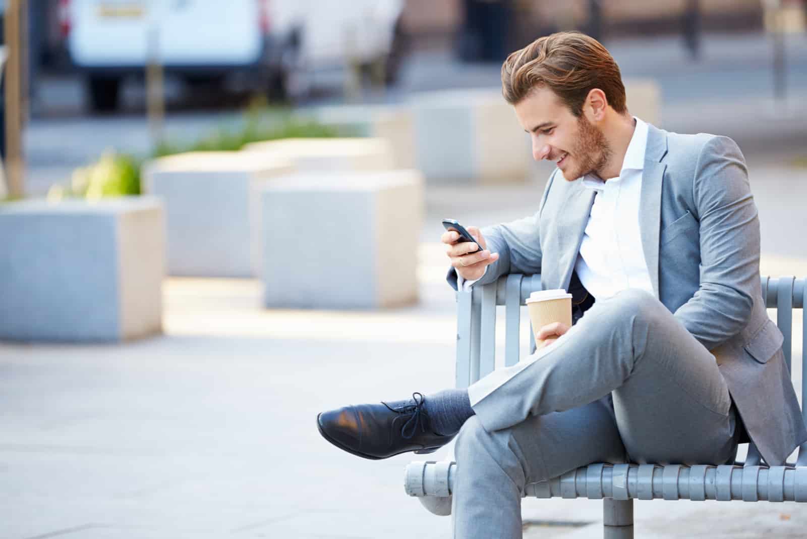 a man sits on a bench and a button on the phone
