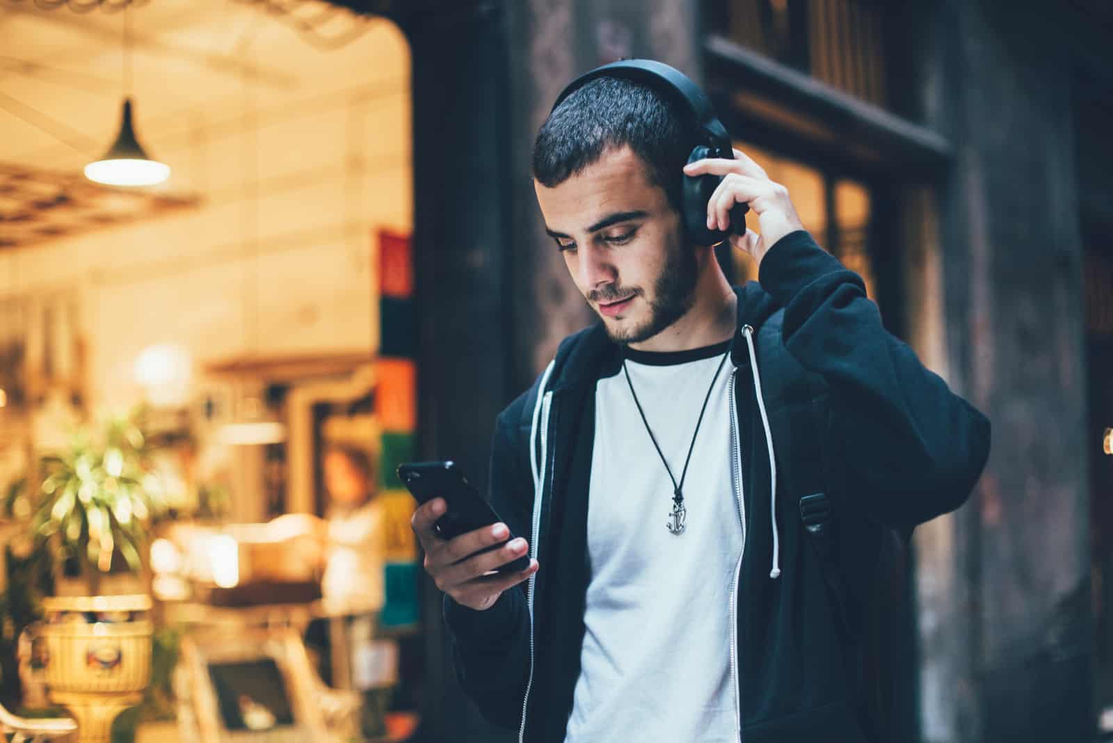 un hombre camina por la calle y botones en el teléfono