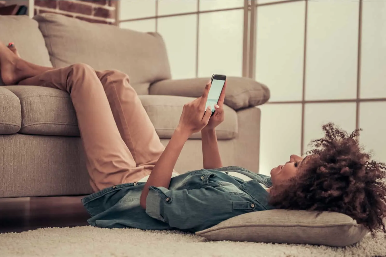 a smiling woman lies on the floor and a button on the phone