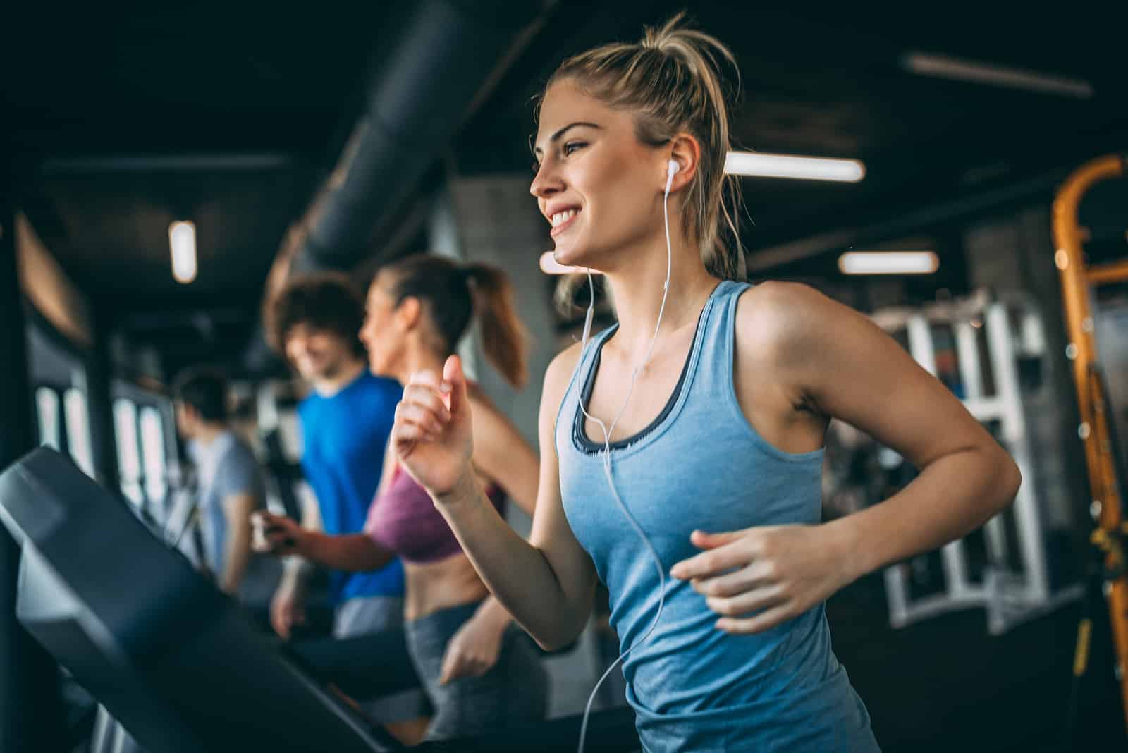 mujer rubia corriendo en el gimnasio