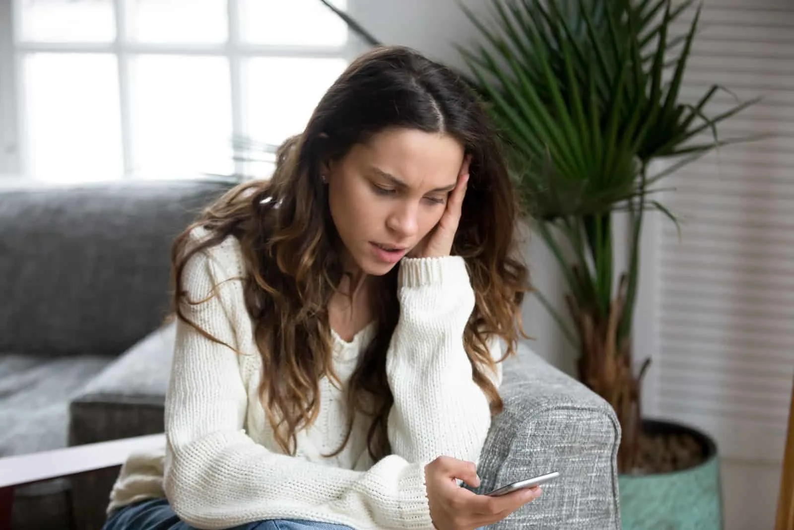 confused young woman reading phone messages