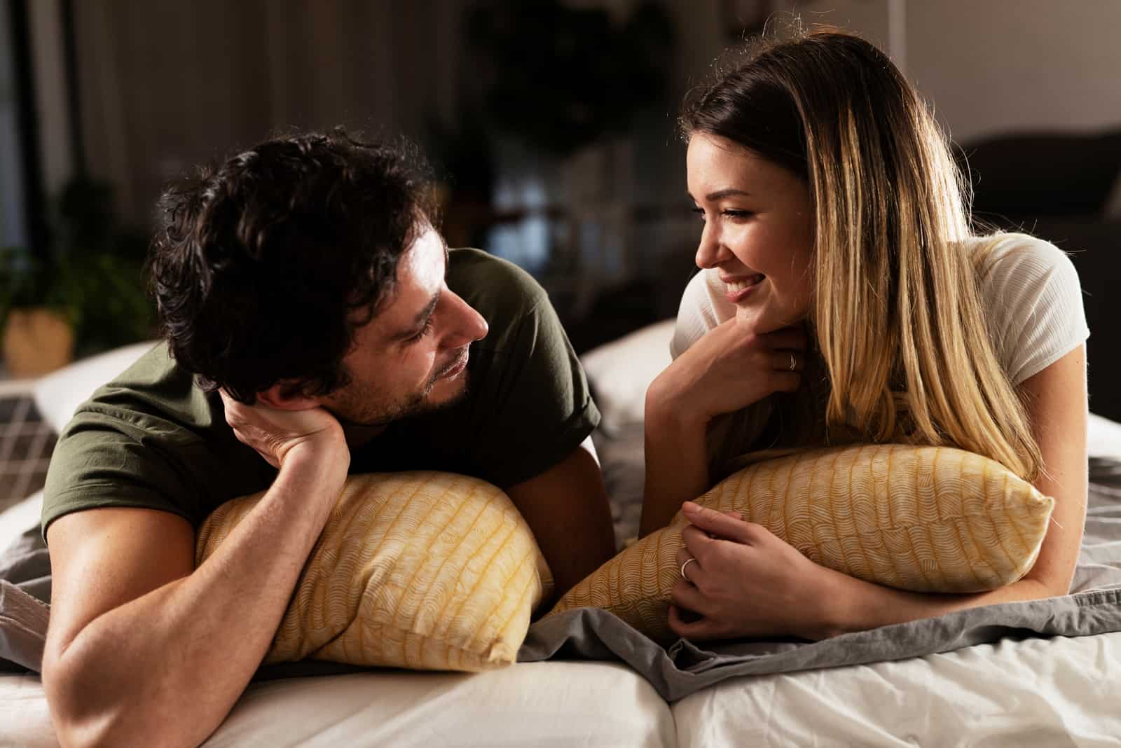 couple talking on the bed at home