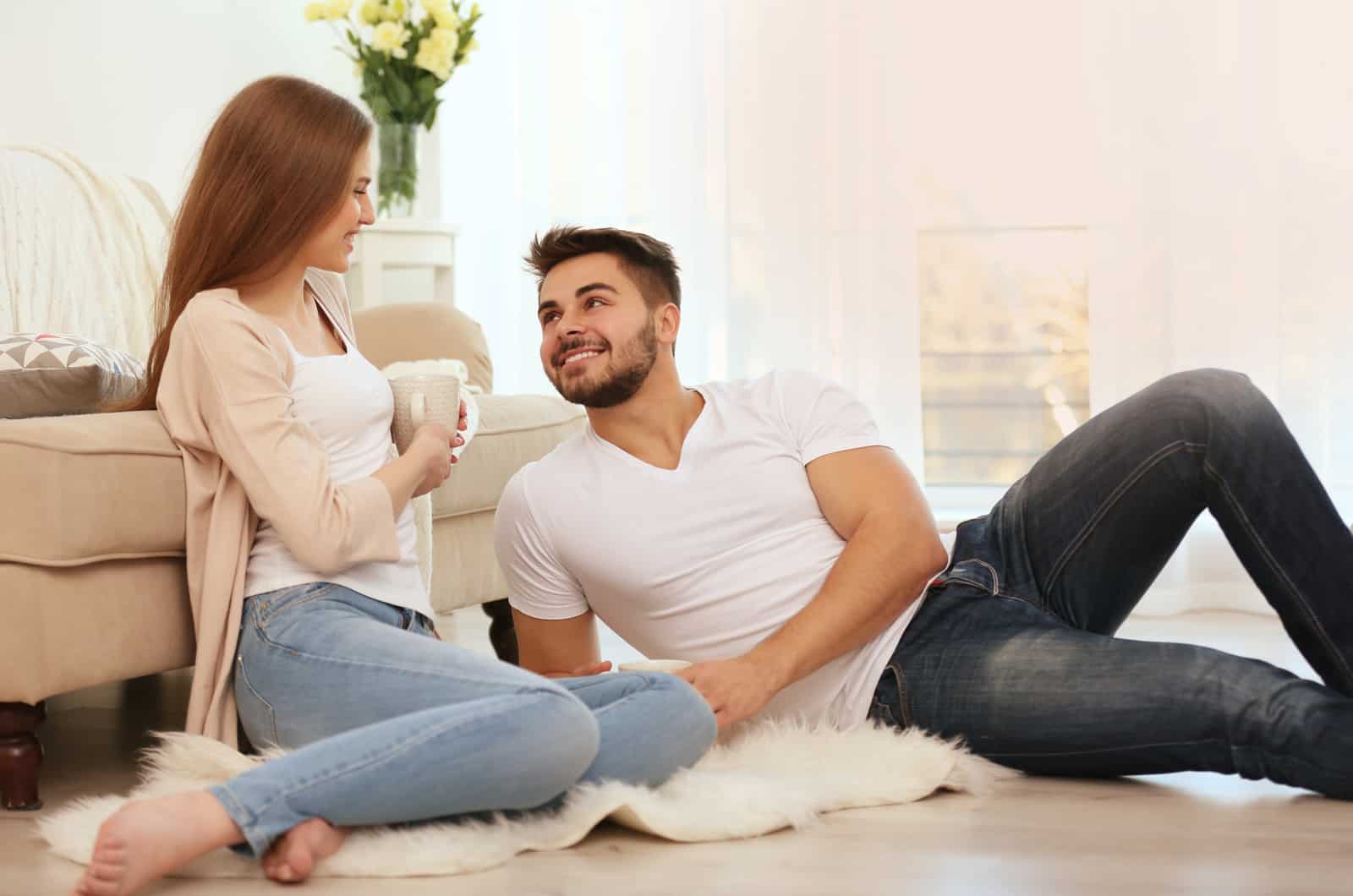 couple talking while sitting on on floor of living room