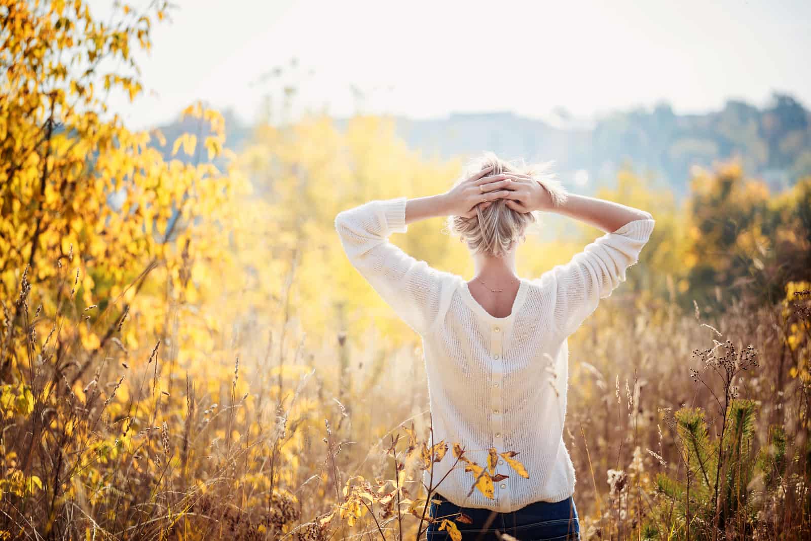 Ragazza che si gode la bellezza di una giornata autunnale di sole nell'erba alta