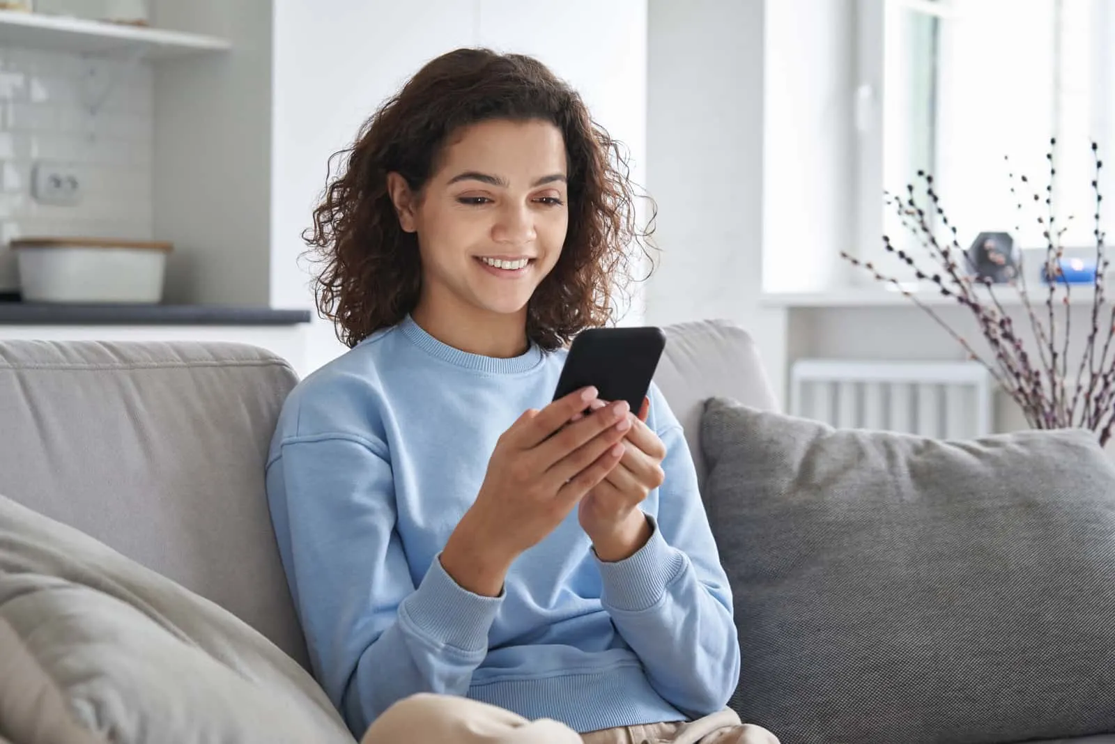 girl sitting in living room texting