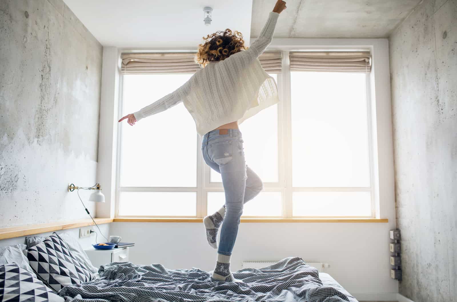 happy woman jumping on bed