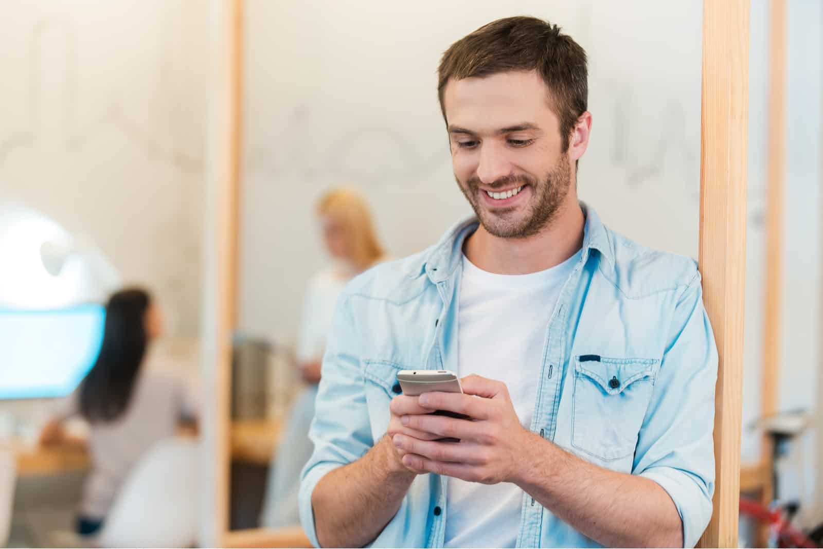 man leaning against the wall button on the phone