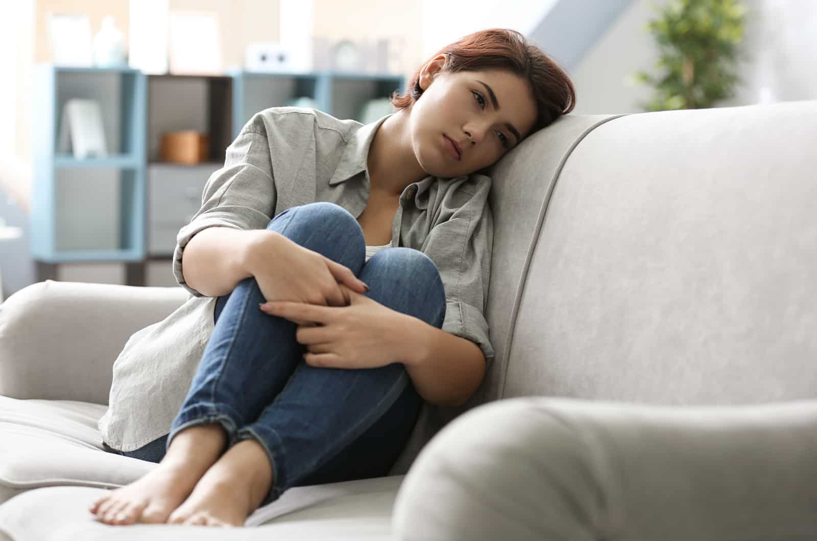 sad young woman sitting on couch
