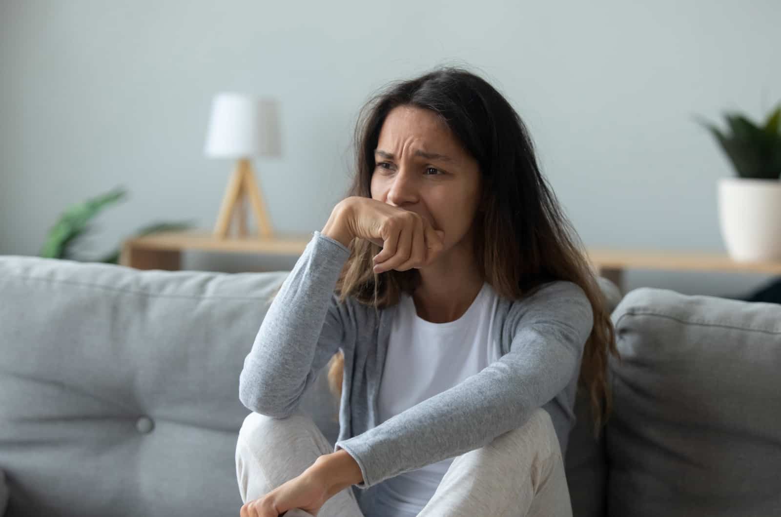 sad young woman sitting on sofa