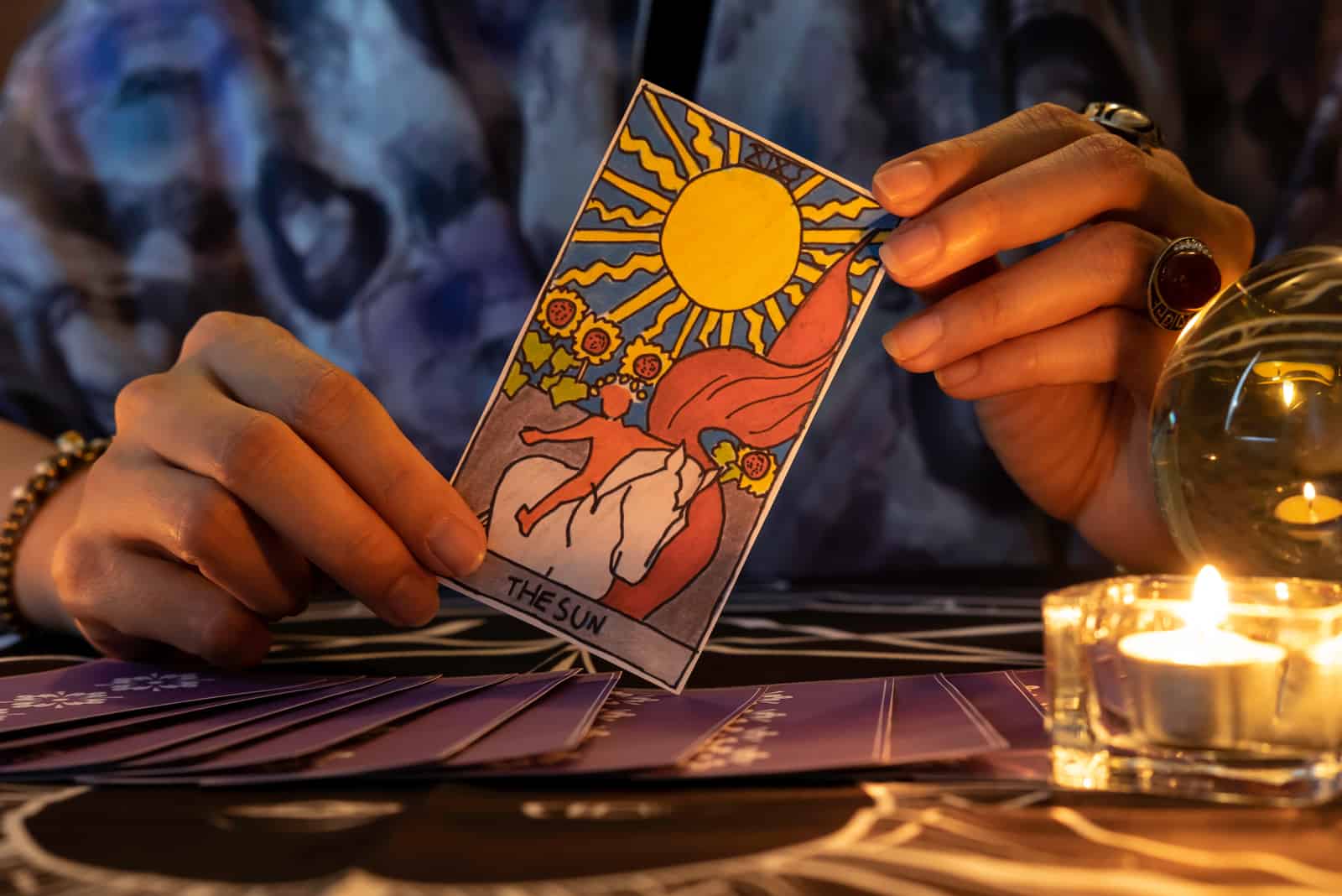 the woman holds a tarot card in her hand