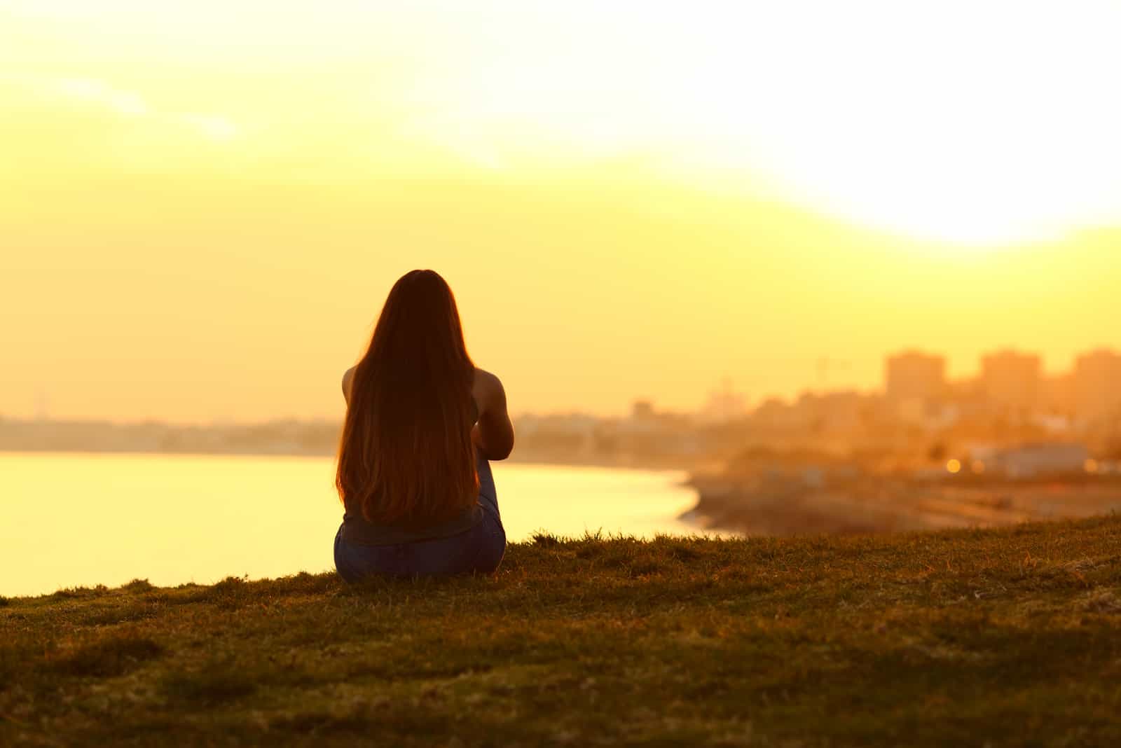 mulher a olhar para um pôr do sol