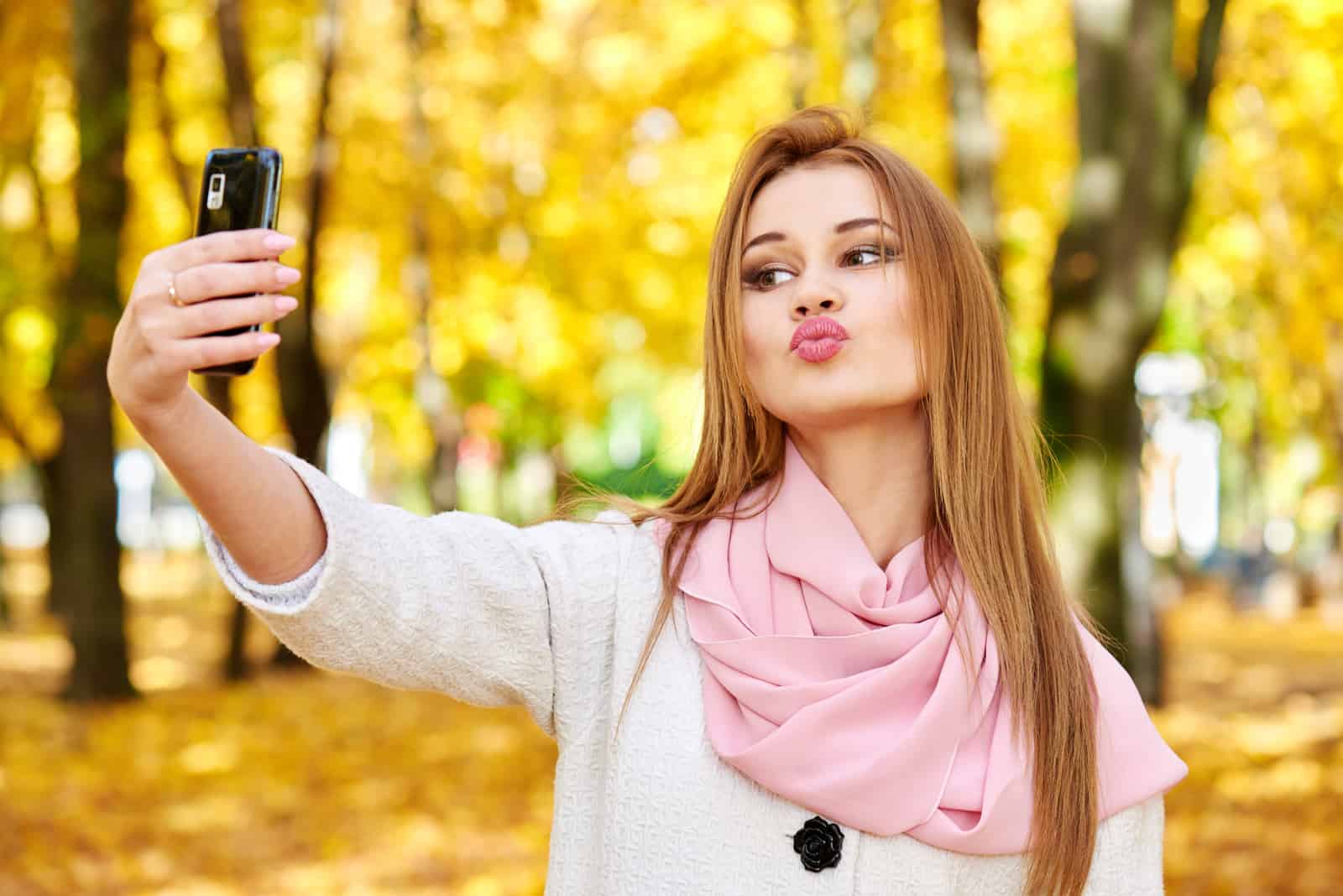 woman making a duckface while taking a selfie