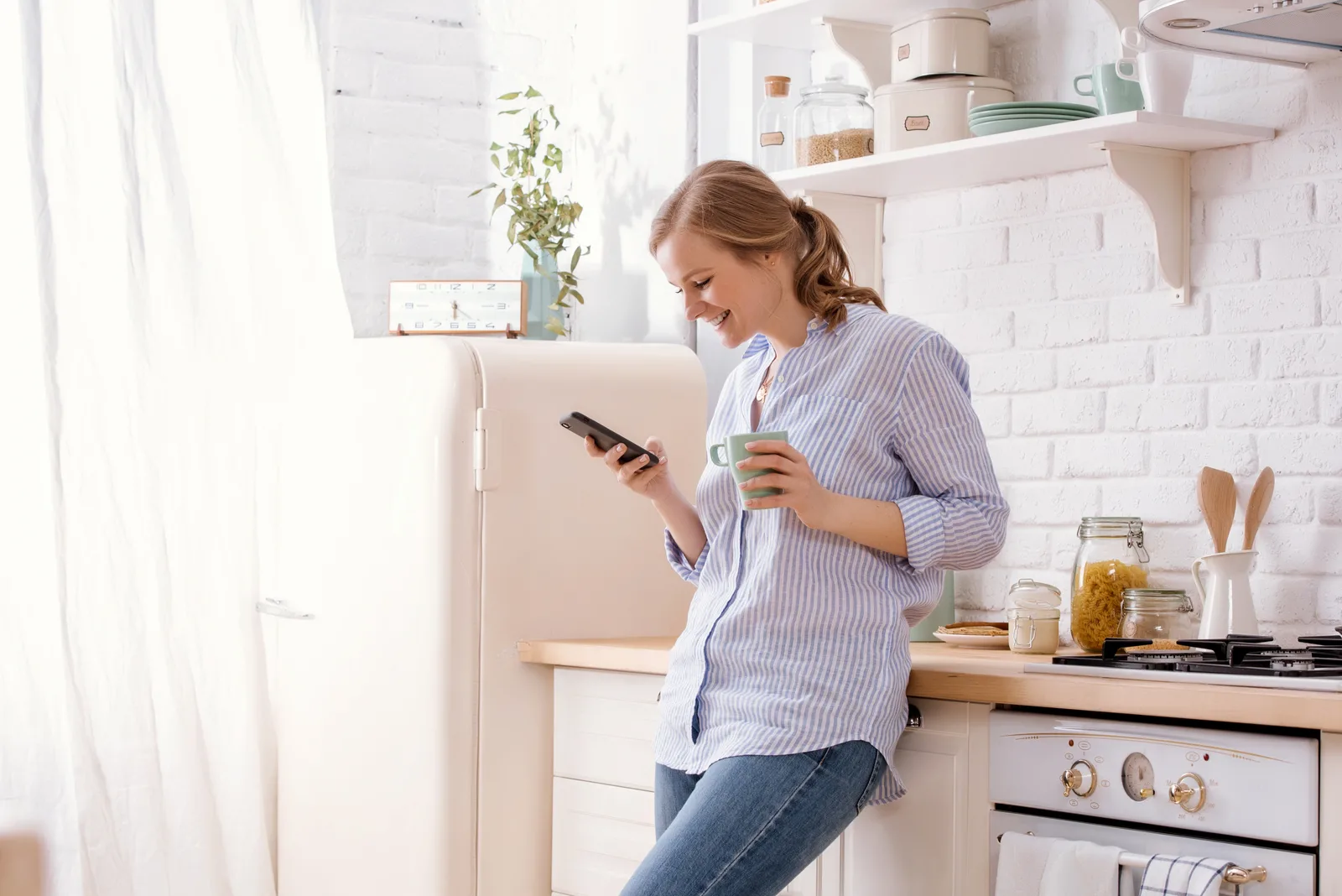 woman reading messages while standing in kitchen