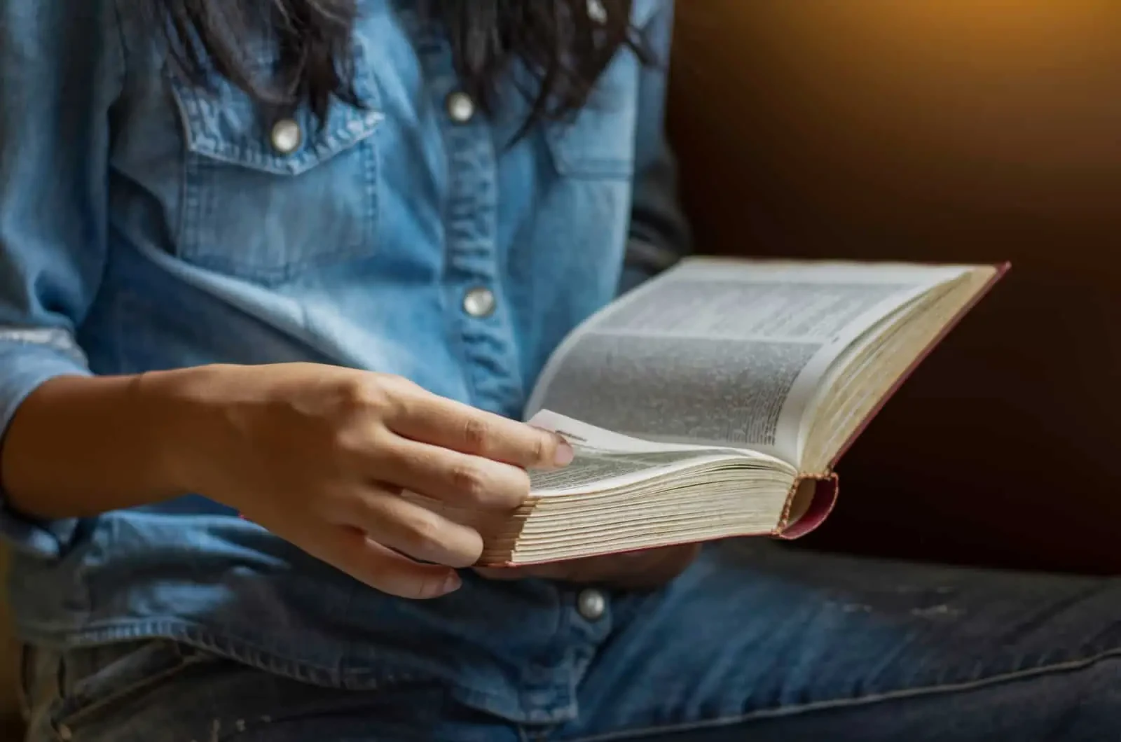 woman turning pages of book
