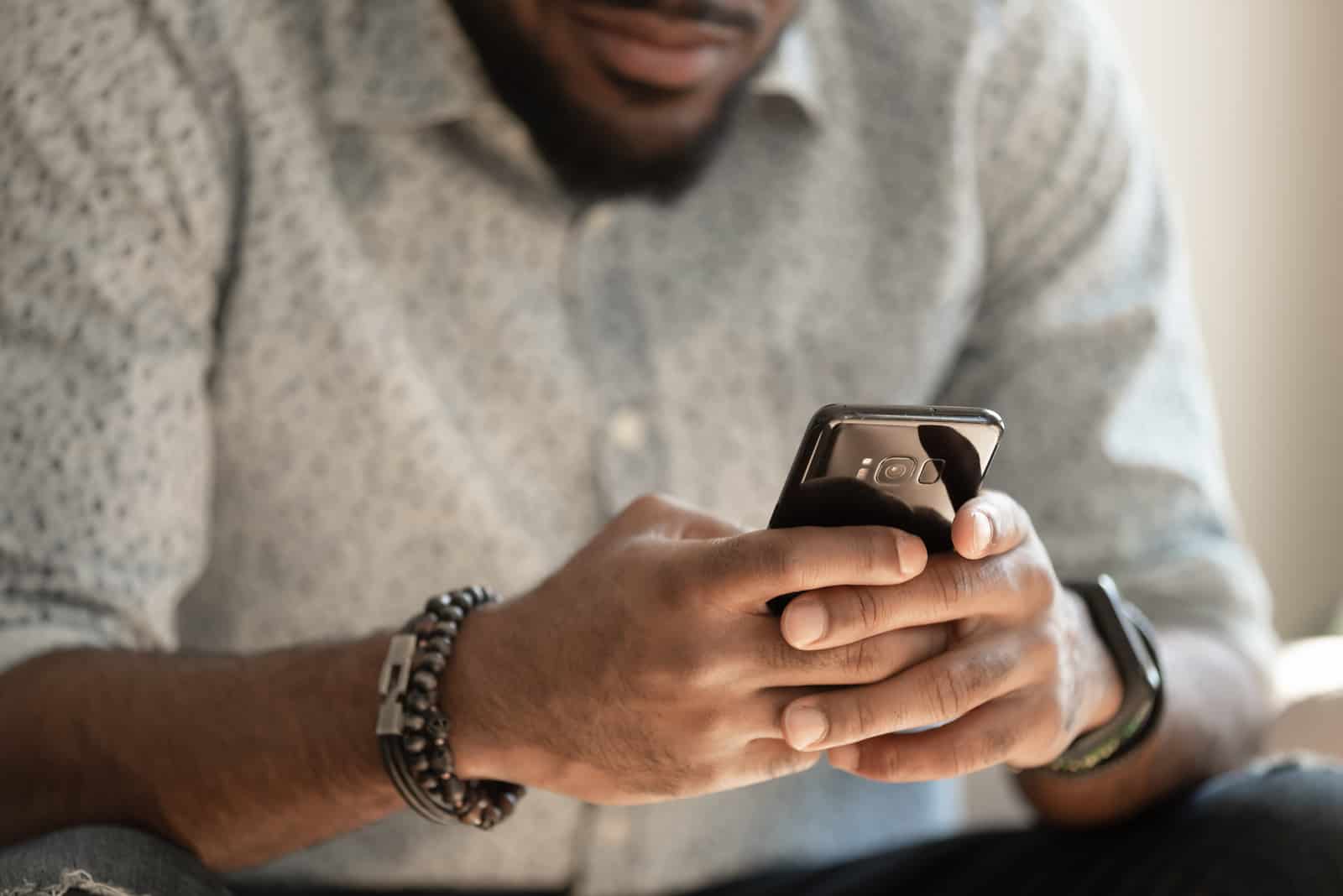 giovane uomo che manda un messaggio a qualcuno sul suo telefono